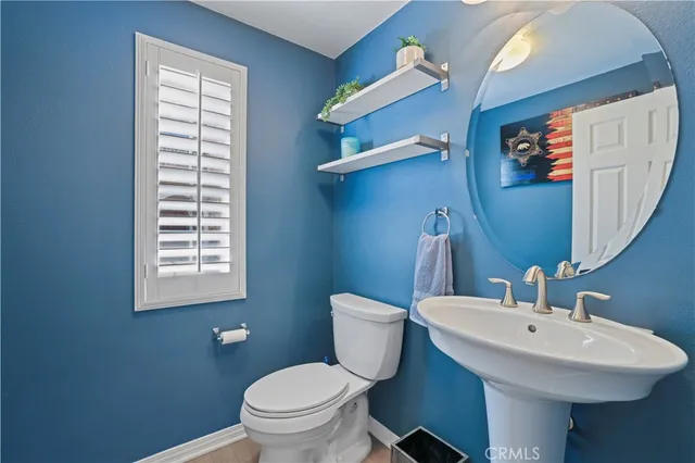 a bathroom with a sink toilet and a mirror