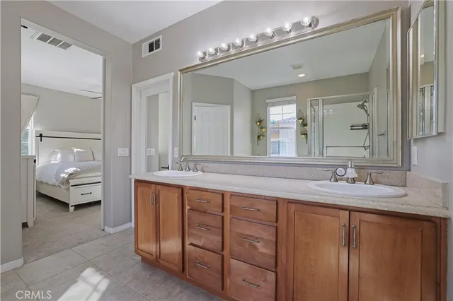 a spacious bathroom with double sink and a large mirror