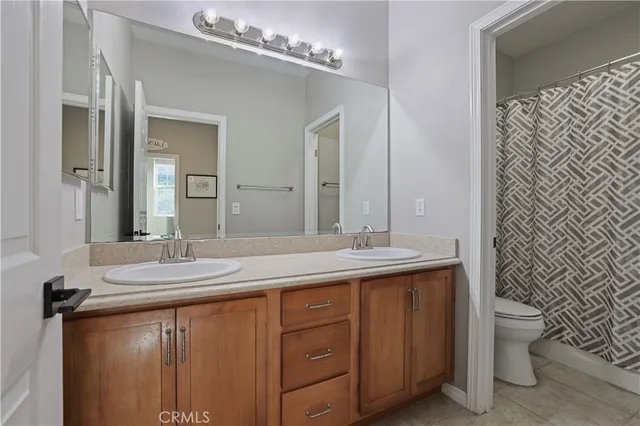 a bathroom with a granite countertop sink a toilet and a mirror
