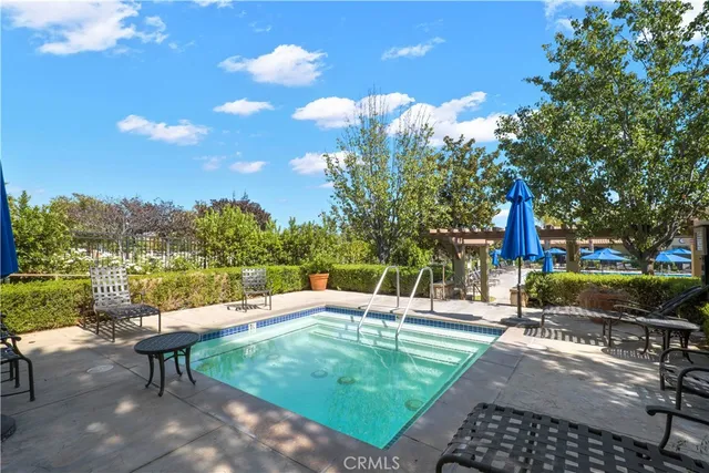 a view of a swimming pool with a patio and a yard