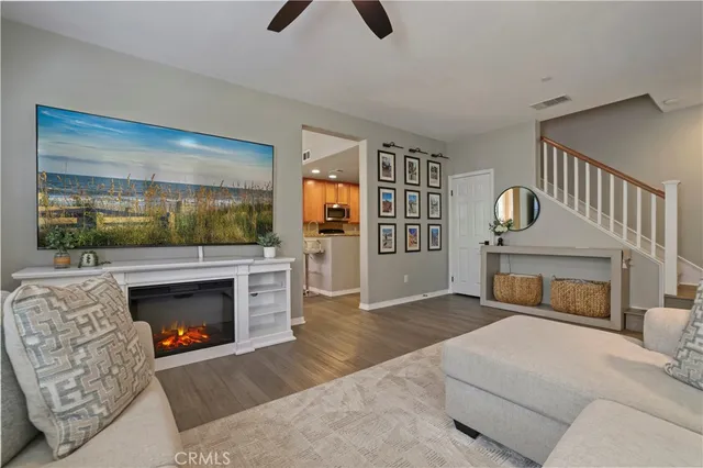 a living room with furniture a flat screen tv and a fireplace