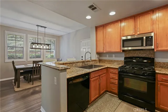 a kitchen with stainless steel appliances granite countertop wooden cabinets stove a sink and dishwasher