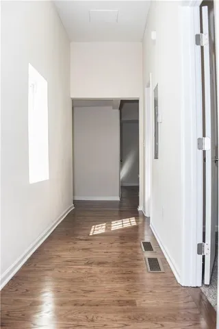 a view of empty room with wooden floor