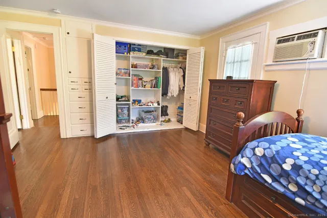 a view of a bedroom with furniture and wooden floor