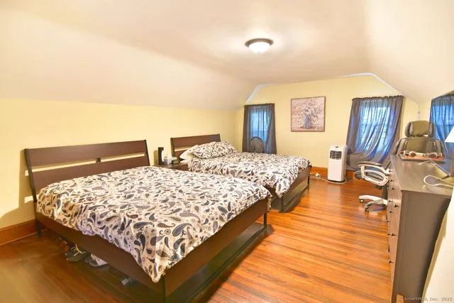 a bedroom with bed and wooden floor