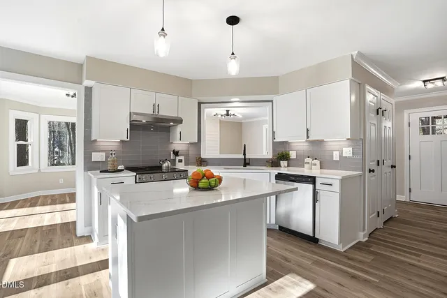 a kitchen with a sink cabinets and wooden floor