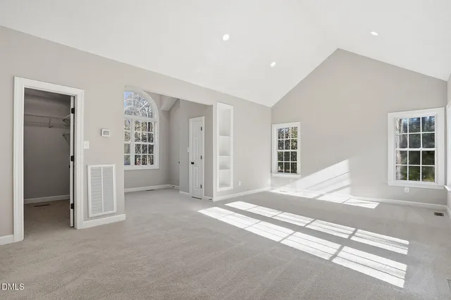 a view of an empty room with wooden floor and closet