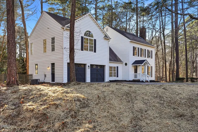 a view of a brick house with many windows next to a yard