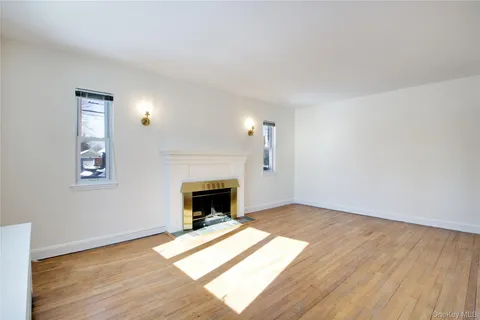a view of empty room with wooden floor and fireplace