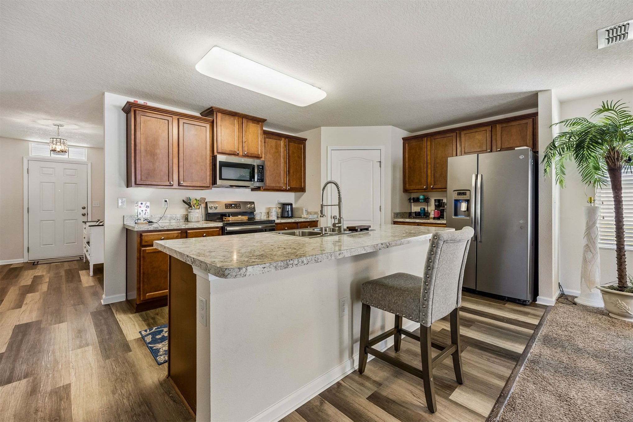 95159 Timberlake Drive Fernandina Beach, FL 32034 - Photo 15 of 33 a kitchen with stainless steel appliances granite countertop a refrigerator a stove a sink a dining table and chairs with wooden floor