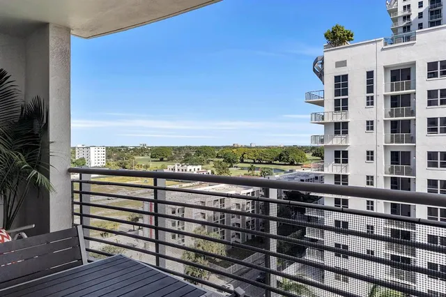 a view of a city from a balcony with outdoor seating