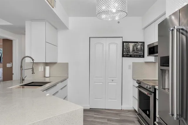 a kitchen with stainless steel appliances granite countertop a refrigerator and a sink