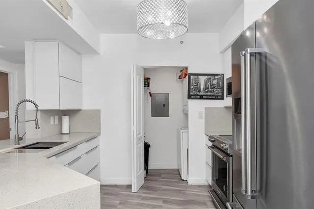 a kitchen with stainless steel appliances granite countertop a refrigerator and a sink