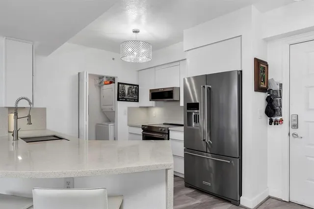 a kitchen with stainless steel appliances a refrigerator sink and microwave