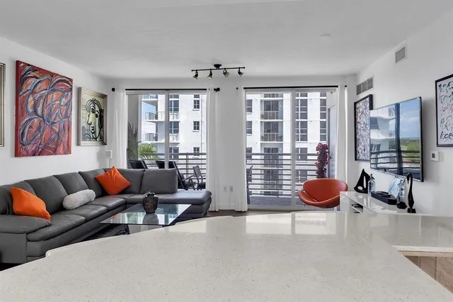 a kitchen with stainless steel appliances a sink a stove a microwave a refrigerator and cabinets