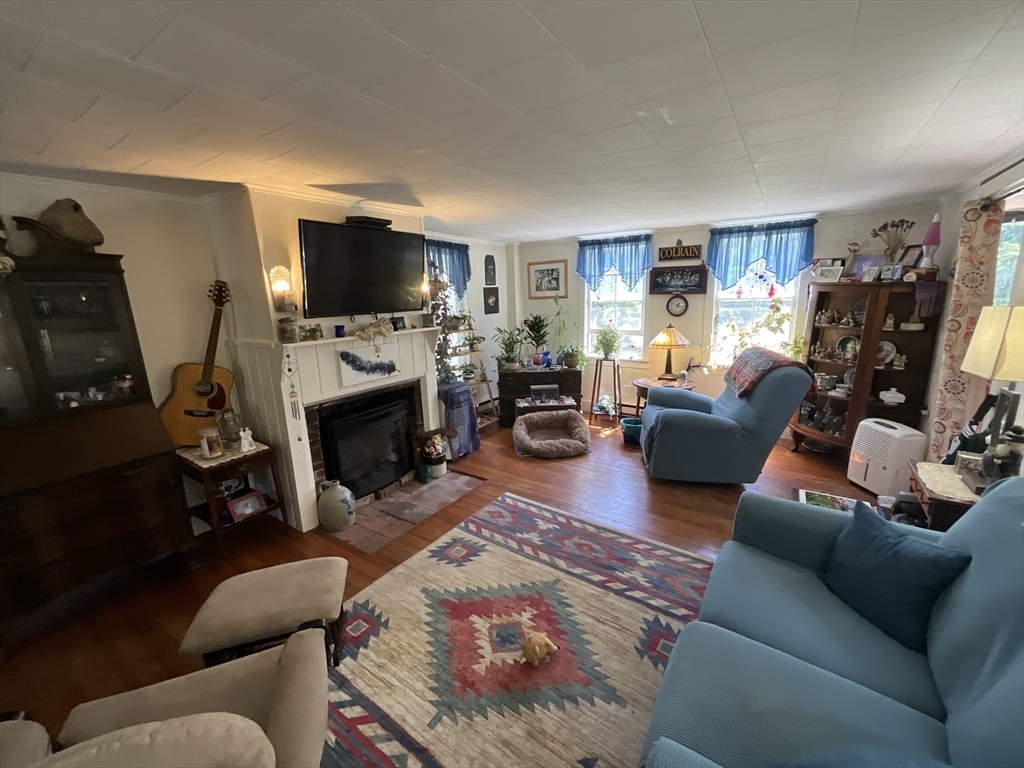 9 Main Road Colrain, MA 01340 - Photo 12 of 40 a living room with furniture a flat screen tv and a fireplace