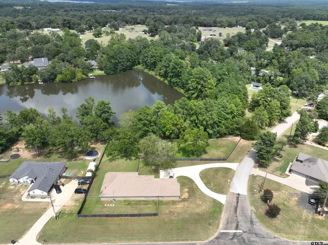 an aerial view of a house with a yard and lake view