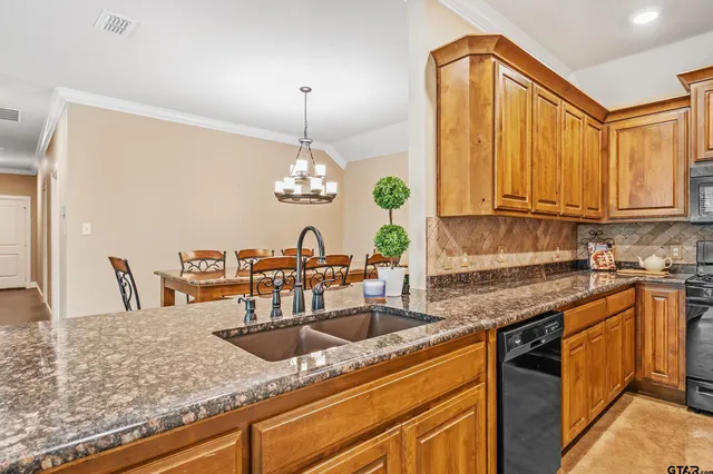 a kitchen with stainless steel appliances granite countertop a sink a stove counter space and cabinets