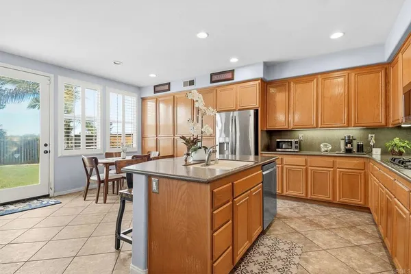 a kitchen with kitchen island granite countertop a sink stove and cabinets