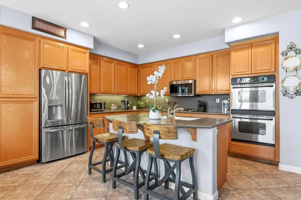 a kitchen with stainless steel appliances granite countertop a refrigerator a stove top oven a sink and dishwasher