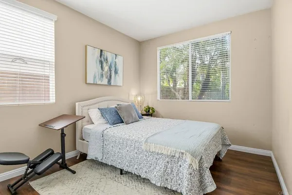 a bedroom with a bed a desk and chair with a window