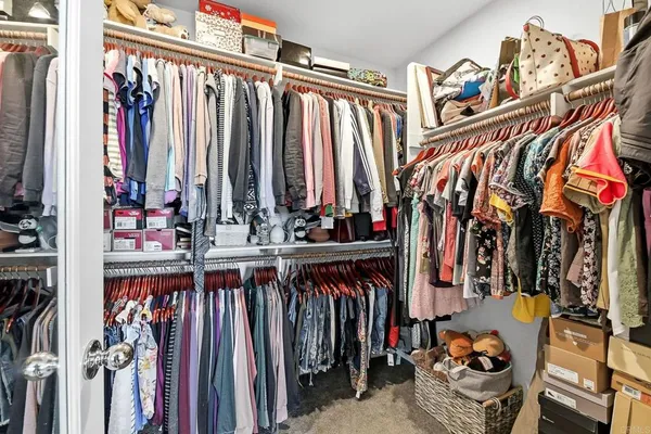 a view of walk in closet with clothes and shoes