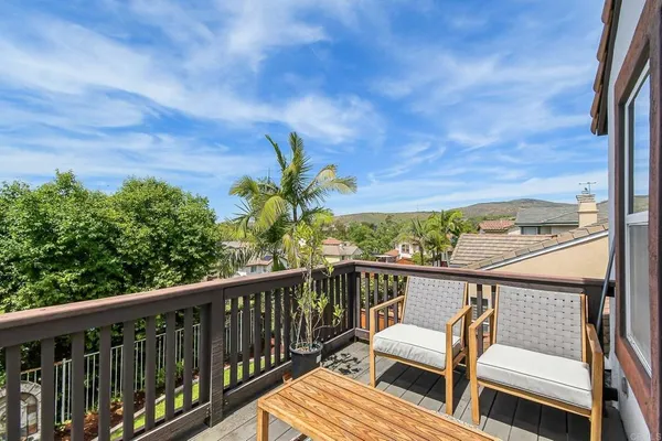 a view of a balcony with wooden floor and fence