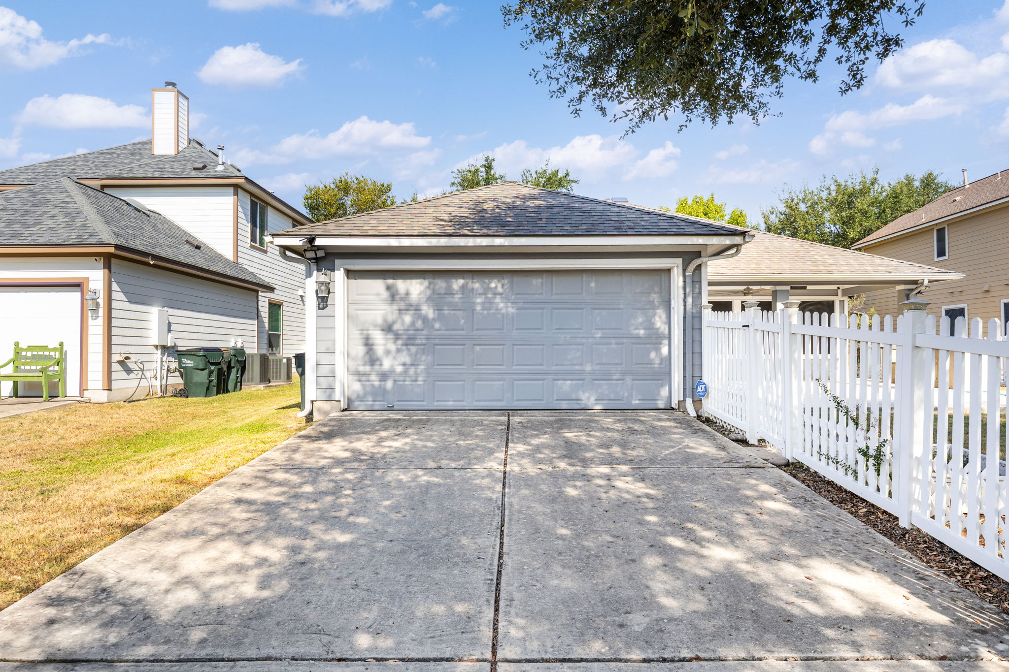 784 Sampson Kyle, TX 78640 - Photo 36 of 40 A spacious concrete driveway leads directly to a detached garage flanked by classic fencing.
