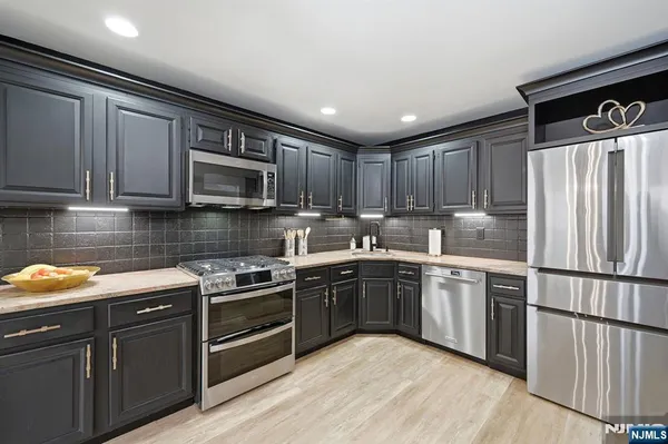 a kitchen with granite countertop wooden cabinets stainless steel appliances and a window