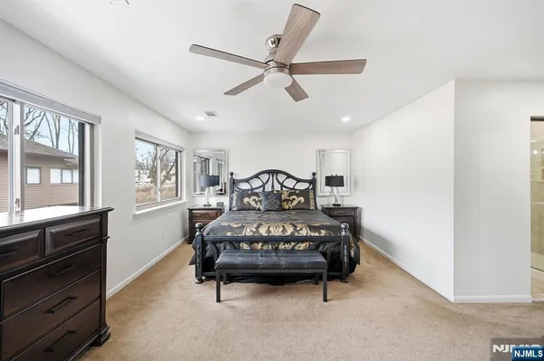 a spacious bedroom with a bed and a chandelier