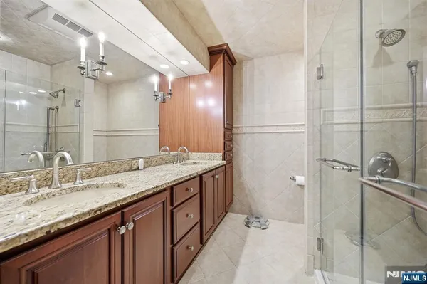 a bathroom with a granite countertop sink mirror and shower