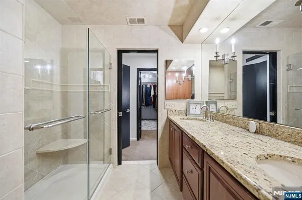 a spacious bathroom with a granite countertop sink mirror and shower