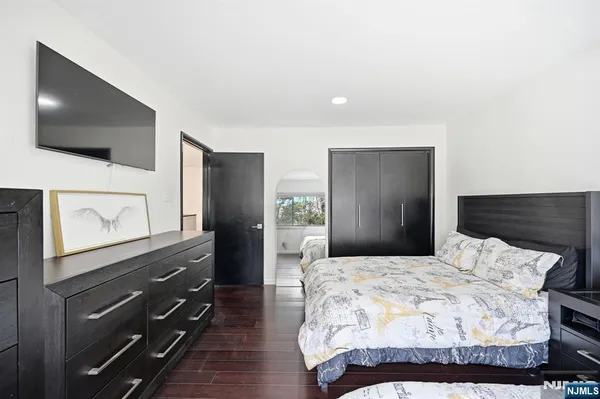 a bedroom with a bed and a flat screen tv