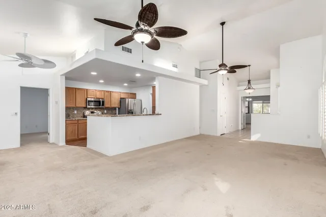 a living room with furniture kitchen view and a chandelier