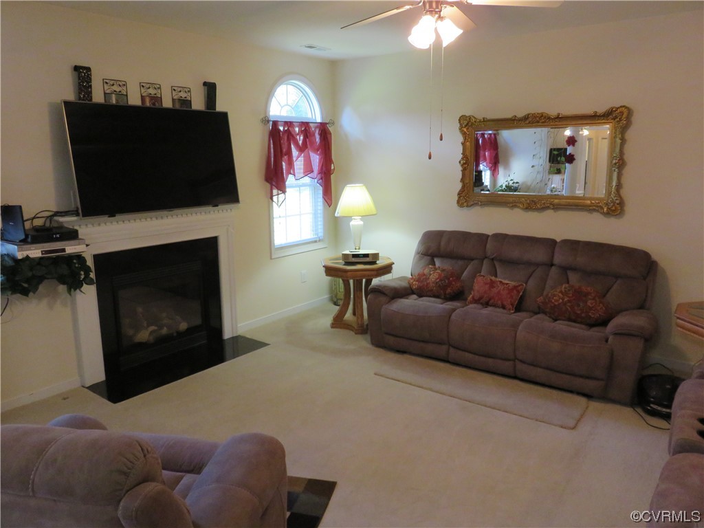 4740 Southmoor Road Richmond, VA 23234 - Photo 16 of 42 a living room with furniture a flat screen tv and a fireplace