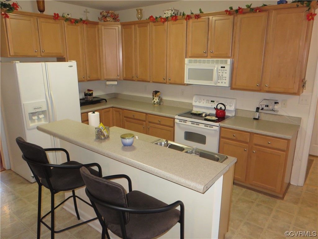 4740 Southmoor Road Richmond, VA 23234 - Photo 20 of 42 a kitchen with a sink a stove a refrigerator and cabinets