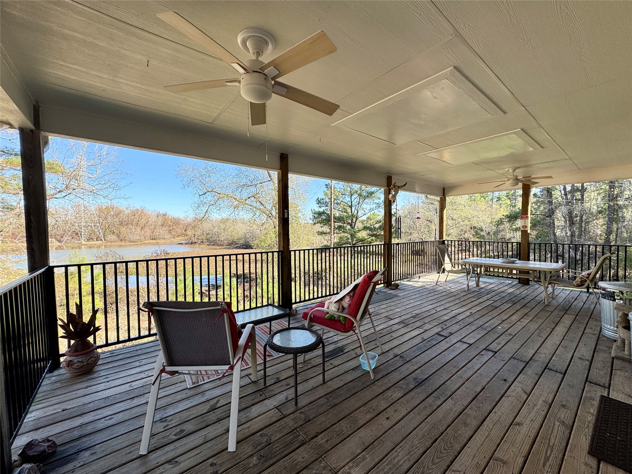55 Lake Road Huntsville, TX 77320 - Photo 7 of 50 Spacious covered deck with ceiling fans, overlooking a serene wooded area and pond. Ideal for relaxing or entertaining. There is also a second covered porch off of the den below.