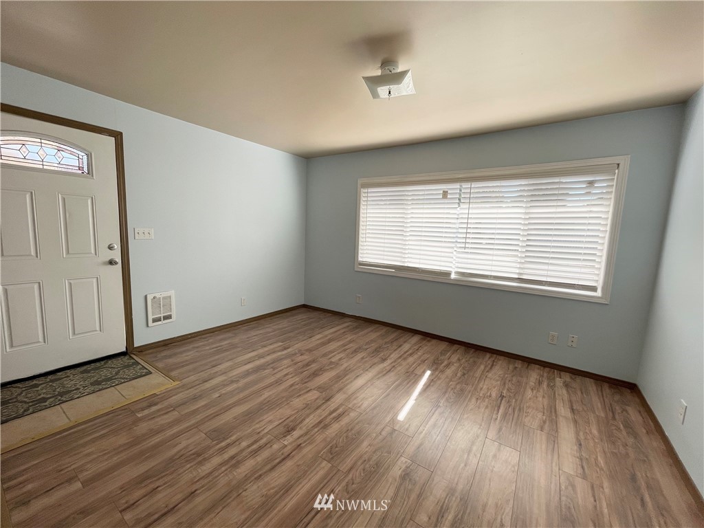 2804 Northeast 7th Street Renton, WA 98056 - Photo 3 of 29 a view of an empty room with wooden floor and a window