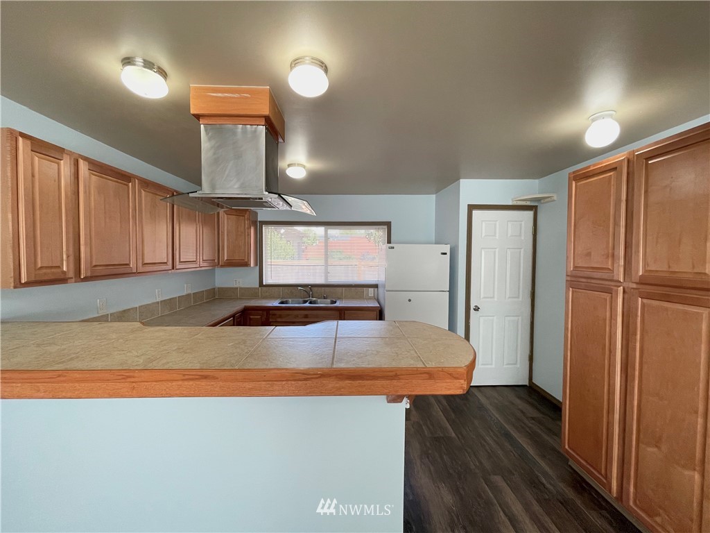 2804 Northeast 7th Street Renton, WA 98056 - Photo 4 of 29 a kitchen with stainless steel appliances granite countertop a refrigerator a sink and a stove