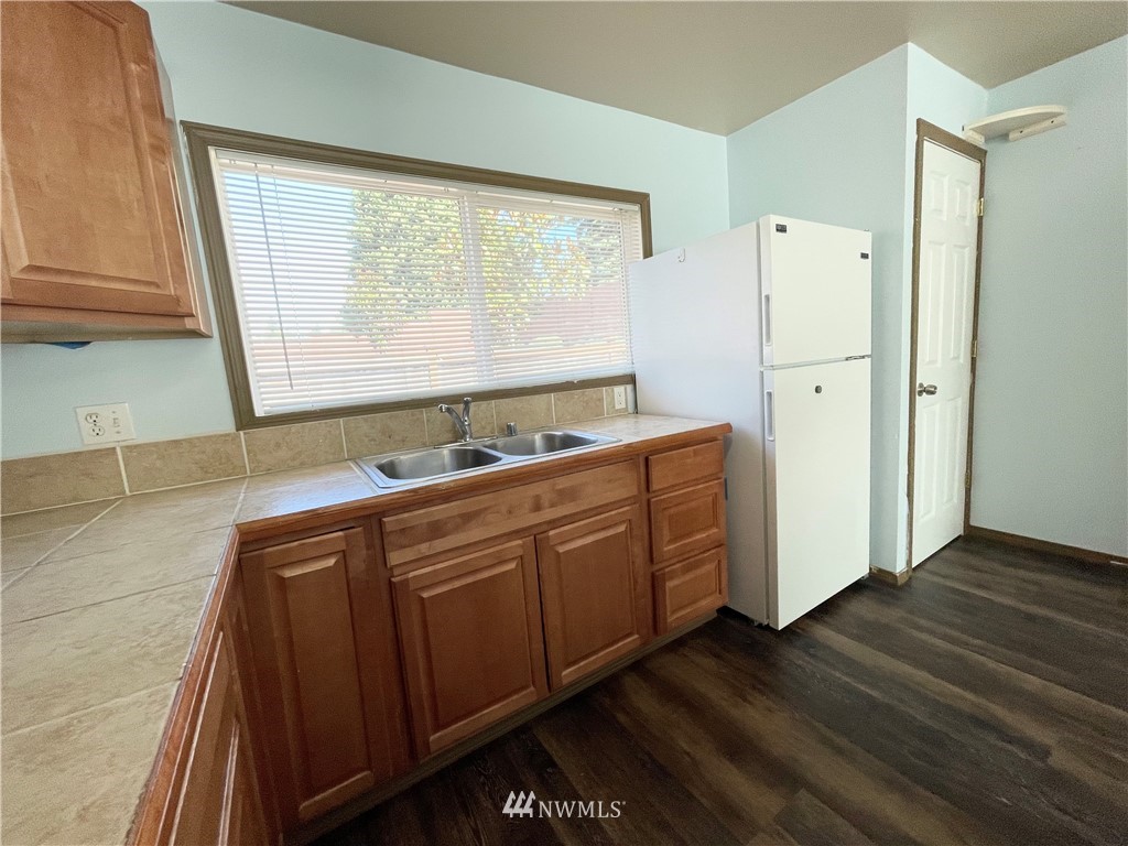 2804 Northeast 7th Street Renton, WA 98056 - Photo 5 of 29 a kitchen with stainless steel appliances granite countertop a refrigerator a sink and white cabinets with wooden floor