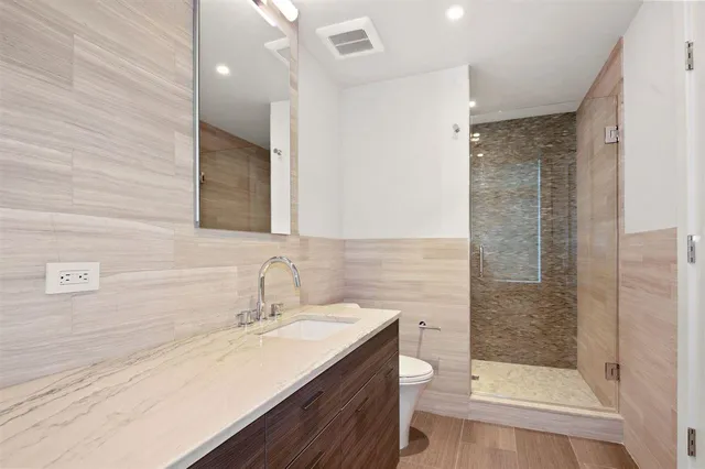 a bathroom with a sink a toilet and shower