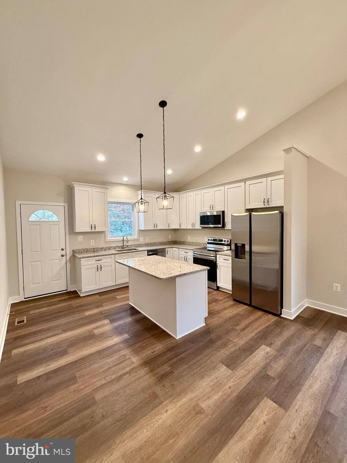 130 Poplar Lane Colonial Beach, VA 22443 - Photo 18 of 74 a large kitchen with kitchen island a stove a sink dishwasher a refrigerator and white cabinets with wooden floor