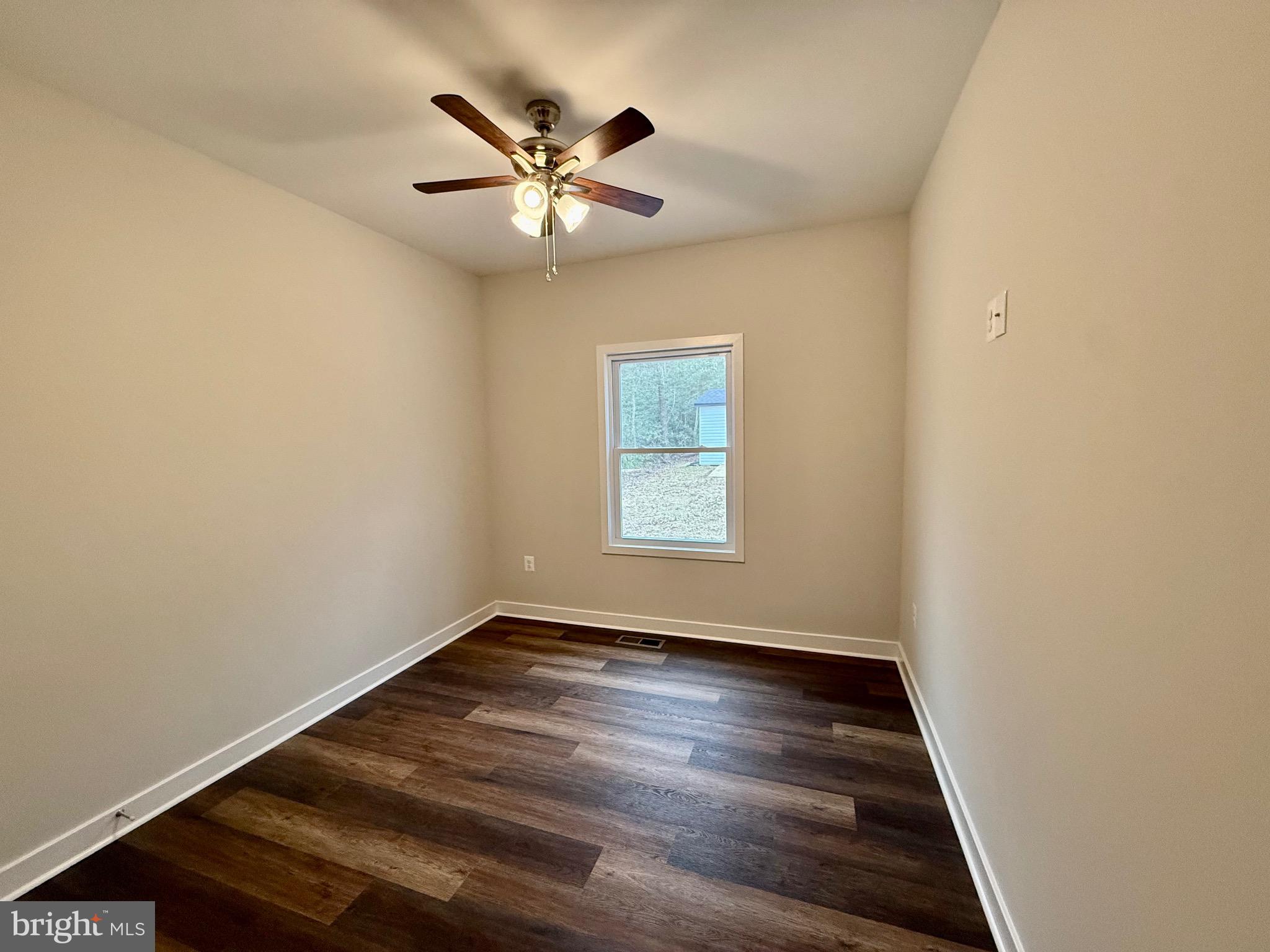 130 Poplar Lane Colonial Beach, VA 22443 - Photo 32 of 74 an empty room with wooden floor chandelier fan and windows