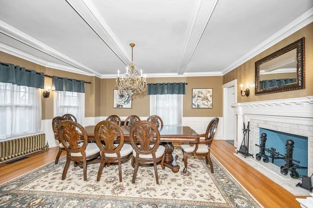 a dining room with furniture a fireplace and large windows