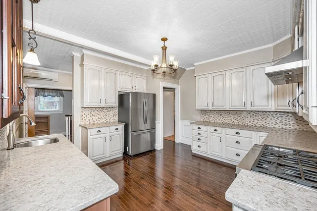 a kitchen with stainless steel appliances granite countertop a stove refrigerator and cabinets