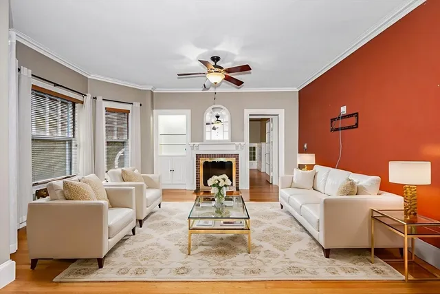 a living room with furniture a fireplace and a large window
