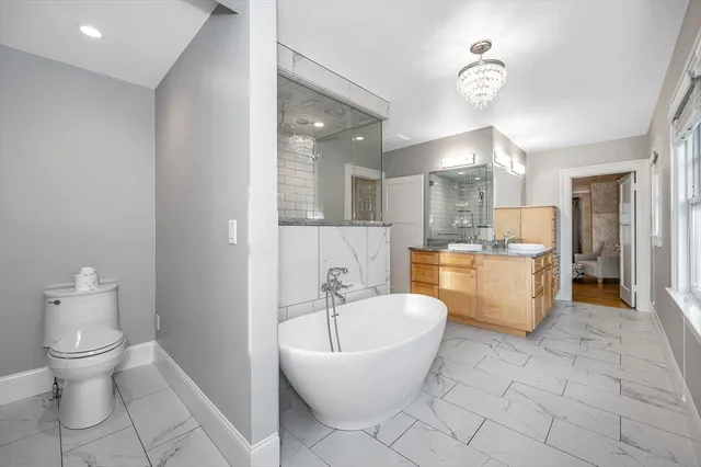 a bathroom with a bathtub sink mirror and toilet