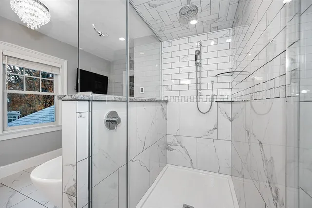 a bathroom with a shower and a flat screen tv