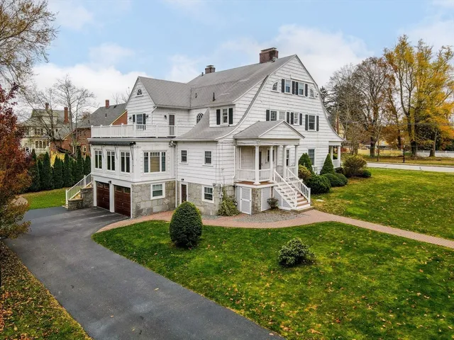 a front view of a house with a garden and trees