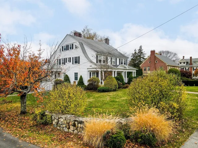 a view of a house with a big yard and large trees